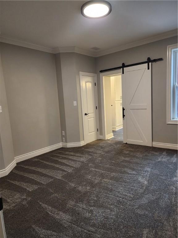 165 45th St, Lawrenceville, PA 15201 - unfurnished bedroom with dark carpet, ornamental molding, a barn door, and baseboards