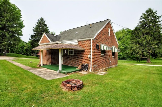 403 Bull Run Rd, Luzerne Twp, PA 15417 - back of property featuring brick siding, a yard, an outdoor fire pit, a shingled roof, and a patio
