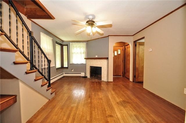 403 Bull Run Rd, Luzerne Twp, PA 15417 - unfurnished living room with wood finished floors, a ceiling fan, arched walkways, stairs, and a fireplace