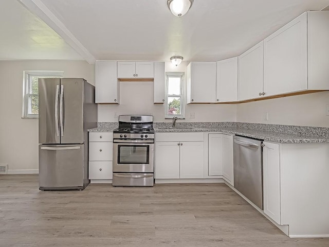 129 Martinique Dr, Penn Hills, PA 15235 - kitchen featuring stainless steel appliances, white cabinets, healthy amount of natural light, and light stone countertops