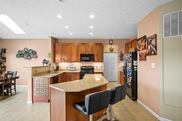 5834 Windsor Ct, South Fayette, PA 15057 - kitchen with black appliances, a sink, recessed lighting, a center island, and baseboards