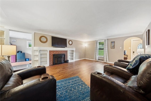 2510 7th St, New Kensington, PA 15068 - living area with wood finished floors, healthy amount of natural light, a brick fireplace, and arched walkways