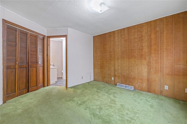 600 Pineview Dr Unit 590, Elizabeth Twp/Boro, PA 15037 - unfurnished bedroom featuring carpet floors, a textured ceiling, wood walls, and ensuite bathroom