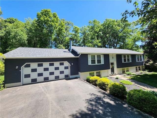 911 Aztec Trl, Coolspring Twp, PA 16137 - bi-level home with an attached garage, asphalt driveway, and roof with shingles