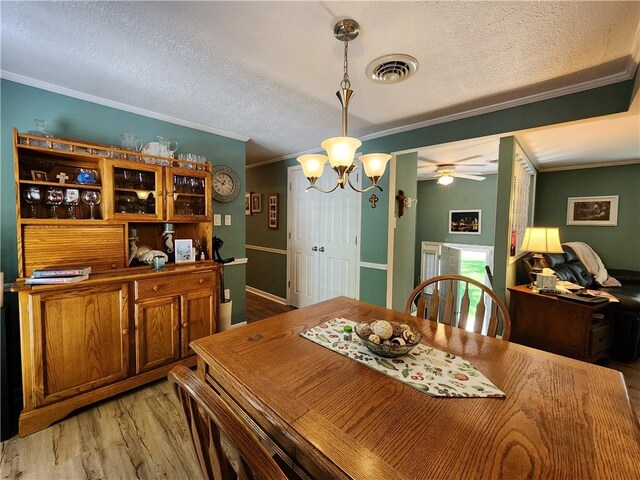 911 Aztec Trl, Coolspring Twp, PA 16137 - dining space with ornamental molding, a textured ceiling, light wood-style flooring, a chandelier, and ceiling fan