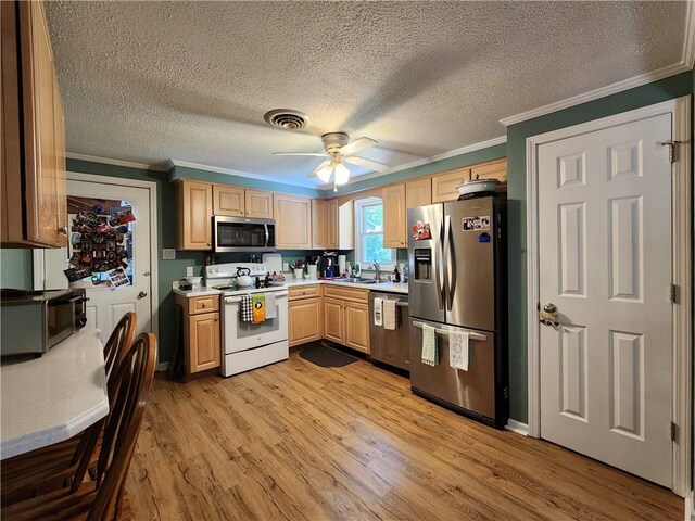 911 Aztec Trl, Coolspring Twp, PA 16137 - kitchen featuring stainless steel appliances, crown molding, light countertops, a sink, and light wood-type flooring