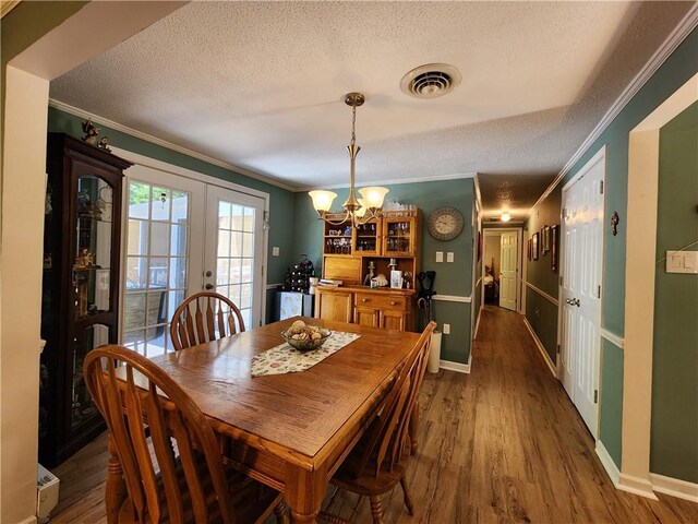 911 Aztec Trl, Coolspring Twp, PA 16137 - dining area with crown molding, a chandelier, a textured ceiling, baseboards, and wood finished floors