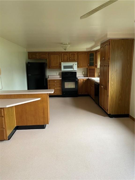 327 Craig St, Manor Twp, PA 16226 - kitchen with black appliances, brown cabinetry, glass insert cabinets, and light countertops