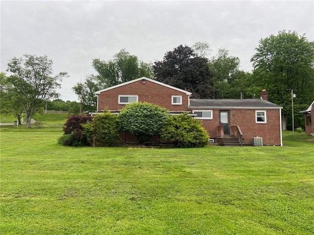 327 Craig St, Manor Twp, PA 16226 - rear view of house featuring brick siding, a yard, cooling unit, and a chimney