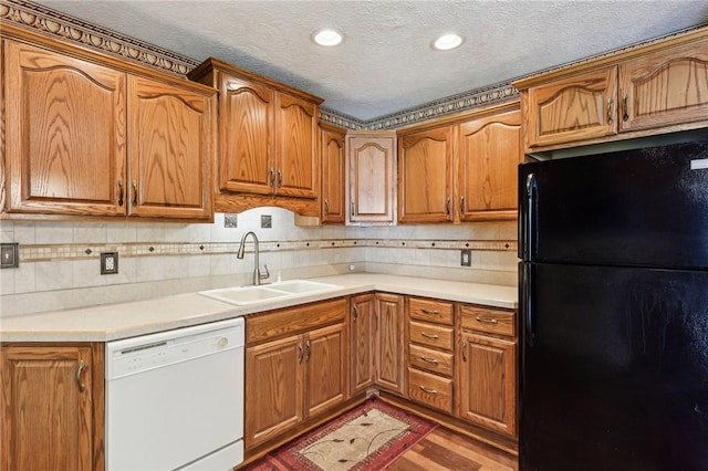 96 Concord Rd, Hermitage, PA 16148 - kitchen featuring freestanding refrigerator, dishwasher, a sink, brown cabinets, and a textured ceiling