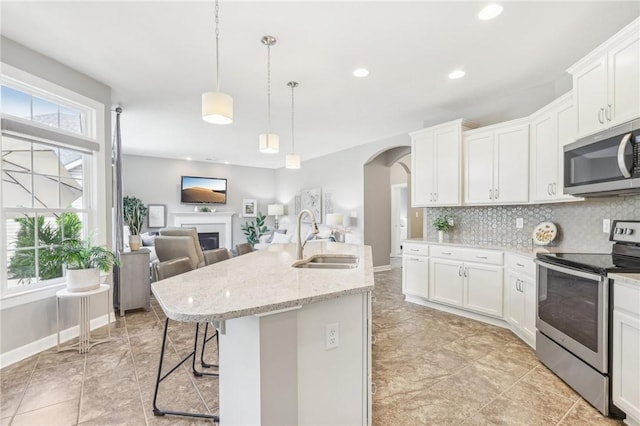 219 Brookside Dr, Cranberry Twp, PA 16066 - kitchen featuring appliances with stainless steel finishes, a sink, arched walkways, open floor plan, and decorative backsplash