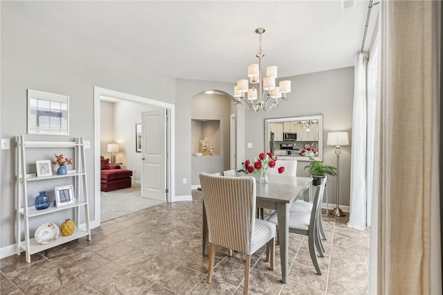 219 Brookside Dr, Cranberry Twp, PA 16066 - dining room with arched walkways, a chandelier, and baseboards