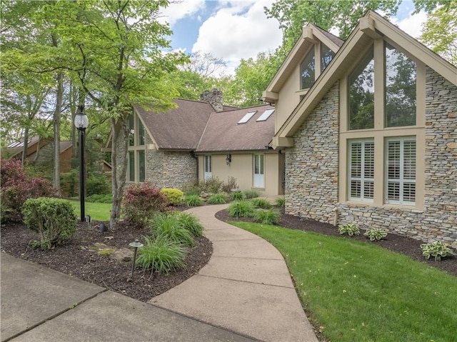 504 Timber Ln, Jefferson Hills, PA 15025 - view of front facade featuring stone siding, stucco siding, a front yard, and a chimney