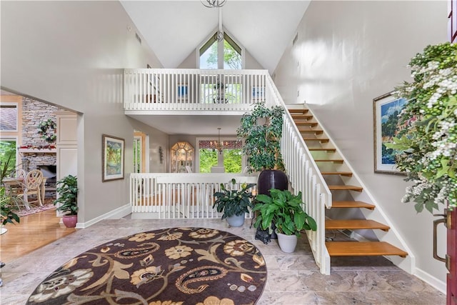 504 Timber Ln, Jefferson Hills, PA 15025 - stairway with plenty of natural light, high vaulted ceiling, a chandelier, a stone fireplace, and baseboards