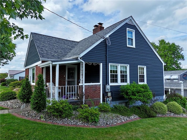 411 Harrison W, Kittanning Boro, PA 16201 - view of front of house featuring covered porch, a chimney, a front lawn, roof with shingles, and brick siding
