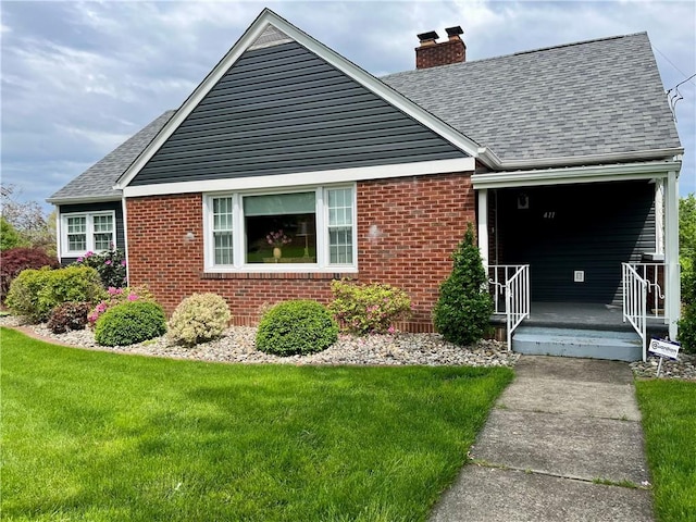 411 Harrison W, Kittanning Boro, PA 16201 - view of front facade with a chimney, roof with shingles, brick siding, a front lawn, and a porch