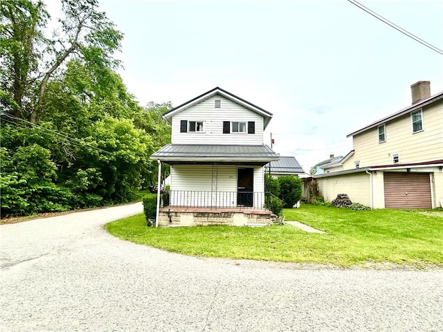 301 4th St, Luzerne Twp, PA 15413 - view of front of house with covered porch, a front yard, a garage, driveway, and metal roof
