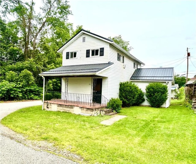 301 4th St, Luzerne Twp, PA 15413 - view of front of house featuring metal roof, a front lawn, covered porch, and a standing seam roof