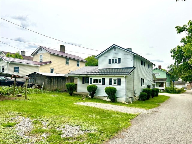 301 4th St, Luzerne Twp, PA 15413 - back of property featuring metal roof, a lawn, and a standing seam roof