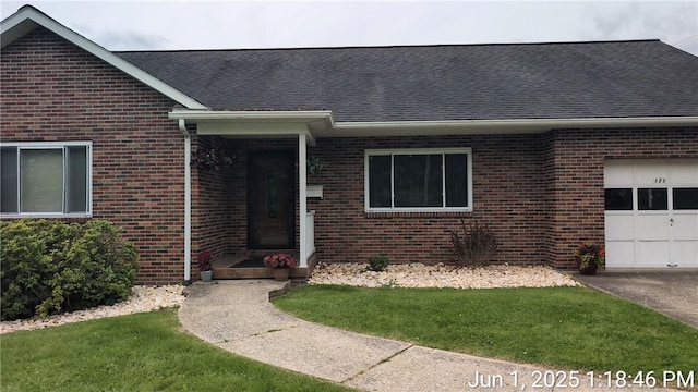175 Sherman Ave, Waynsbrg/Frankln Twp, PA 15370 - property entrance featuring a garage, brick siding, a shingled roof, and a yard