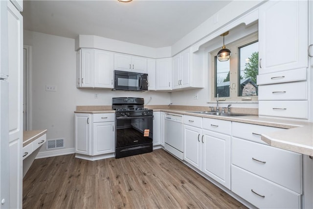 126 Woodhall Dr, Baldwin Boro, PA 15236 - kitchen with black appliances, a sink, white cabinetry, light wood-style floors, and light countertops