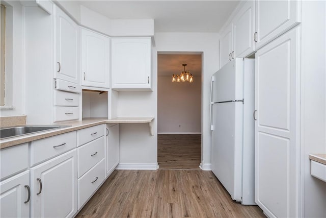 126 Woodhall Dr, Baldwin Boro, PA 15236 - kitchen with freestanding refrigerator, light wood finished floors, a chandelier, white cabinets, and baseboards