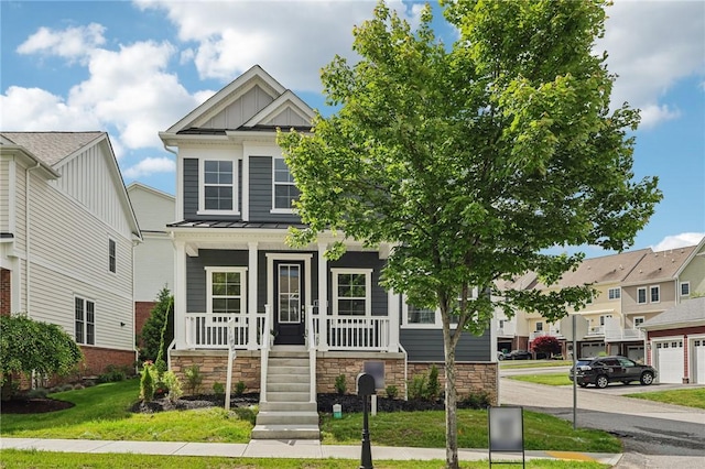 1213 Newbury Highland, South Fayette, PA 15017 - view of front of property with covered porch, a standing seam roof, board and batten siding, stone siding, and a front lawn