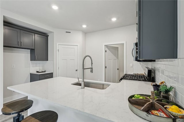 1213 Newbury Highland, South Fayette, PA 15017 - kitchen featuring a sink, light stone countertops, a peninsula, tasteful backsplash, and a kitchen bar