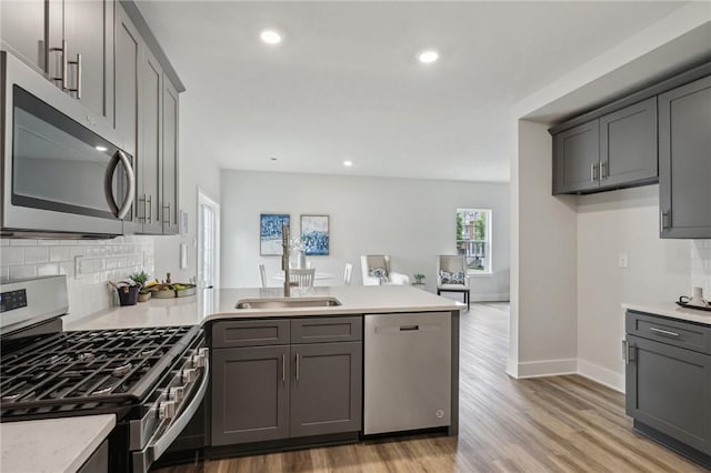 1213 Newbury Highland, South Fayette, PA 15017 - kitchen featuring stainless steel appliances, a peninsula, a sink, decorative backsplash, and recessed lighting