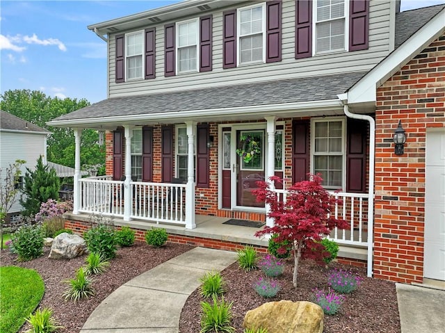 115 Lawrence Dr, Brighton Twp, PA 15009 - view of exterior entry featuring covered porch, brick siding, and a shingled roof