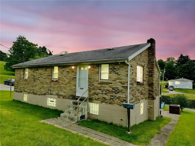 1230 Frank Ave, Jeannette, PA 15644 - bungalow-style house featuring entry steps, a chimney, a front yard, and a shingled roof