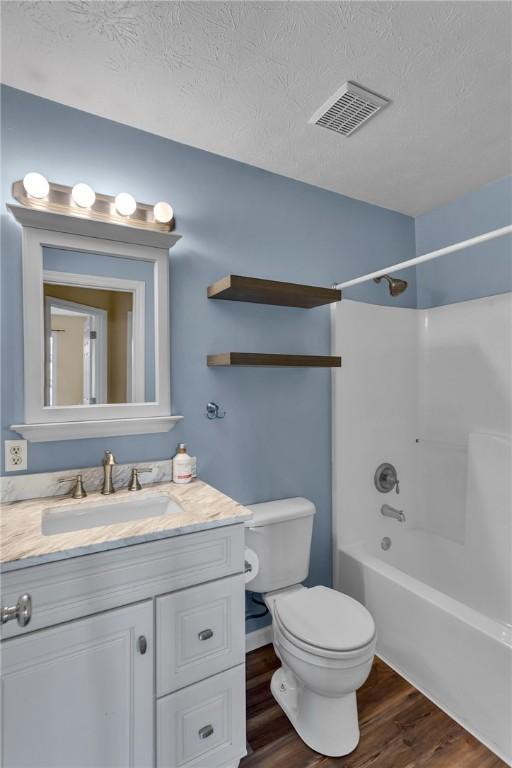 929 White Water, Adams Twp, PA 16046 - bathroom featuring wood finished floors, toilet, vanity, shower / tub combination, and a textured ceiling
