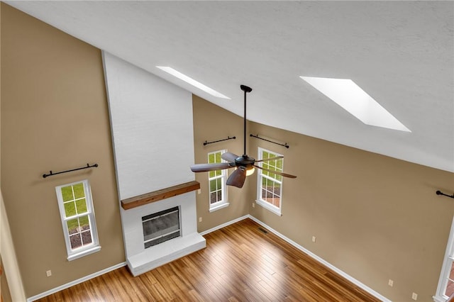 929 White Water, Adams Twp, PA 16046 - unfurnished living room featuring a skylight, a ceiling fan, lofted ceiling, wood finished floors, and a fireplace