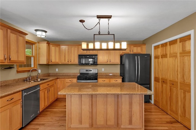 929 White Water, Adams Twp, PA 16046 - kitchen featuring black appliances, a sink, a center island, light wood finished floors, and light stone counters