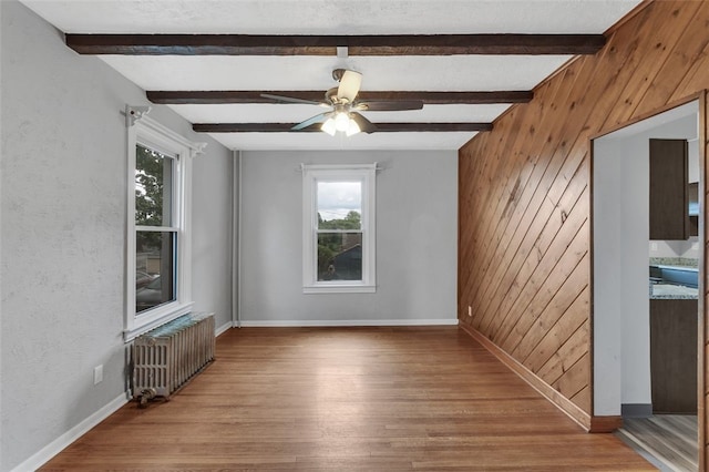 901 Punta Gorda Ave, East Mckeesport, PA 15035 - unfurnished room with radiator, wooden walls, wood finished floors, beam ceiling, and baseboards
