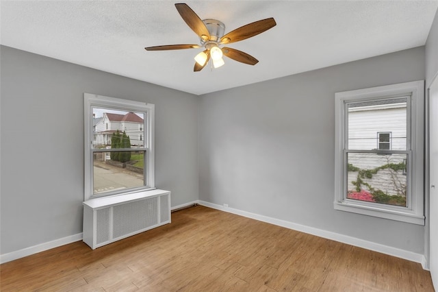 901 Punta Gorda Ave, East Mckeesport, PA 15035 - unfurnished room with radiator, baseboards, light wood-style flooring, and a ceiling fan