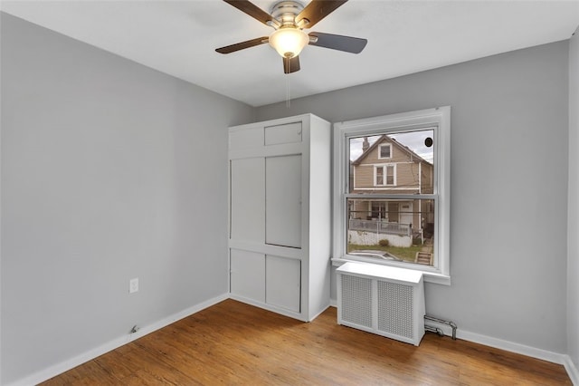 901 Punta Gorda Ave, East Mckeesport, PA 15035 - unfurnished bedroom with baseboards, wood finished floors, radiator heating unit, and ceiling fan
