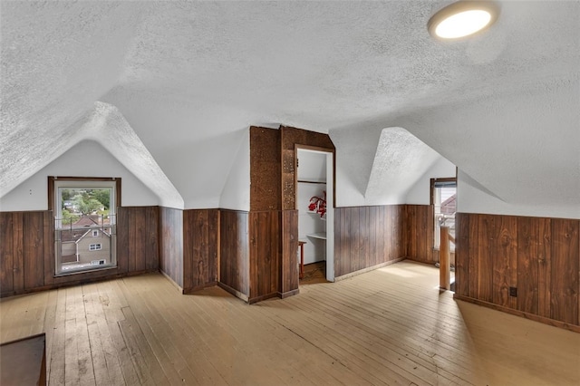 901 Punta Gorda Ave, East Mckeesport, PA 15035 - additional living space with a textured ceiling, light wood-style flooring, wood walls, wainscoting, and lofted ceiling