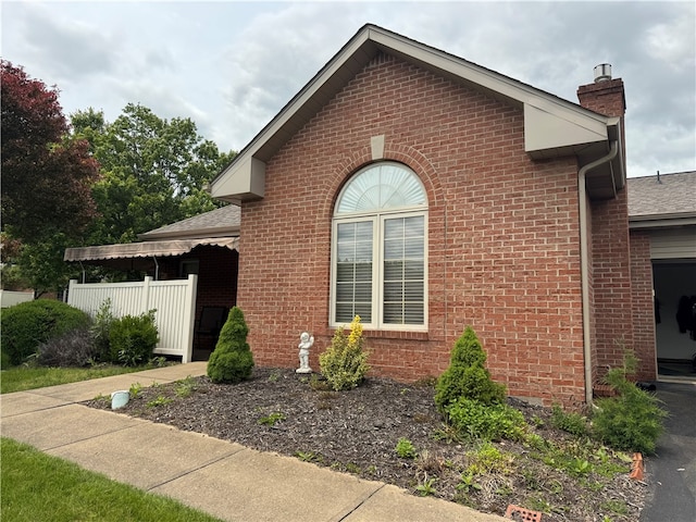 127 Crosswynds Unit 127, Chippewa Twp, PA 15010 - view of home's exterior with a chimney, brick siding, and roof with shingles