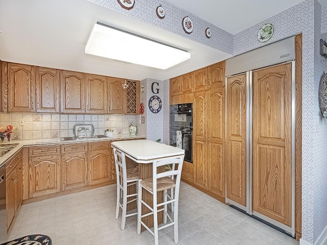 1 Trimont Ln Unit 2115A, Mt Washington, PA 15211 - kitchen featuring light countertops, stainless steel appliances, a breakfast bar area, a kitchen island, and brown cabinetry