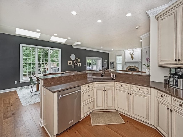 906 Big Bear Ct, Adams Twp, PA 15044 - kitchen with cream cabinets, a sink, stainless steel dishwasher, a fireplace, and wood finished floors