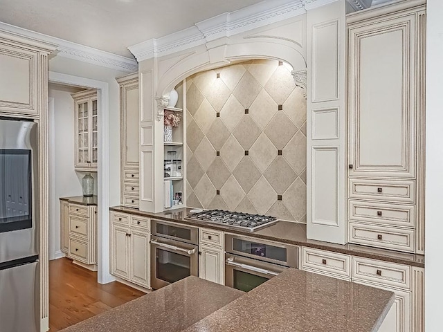 906 Big Bear Ct, Adams Twp, PA 15044 - kitchen with stainless steel appliances, cream cabinetry, dark wood-style flooring, backsplash, and dark stone counters