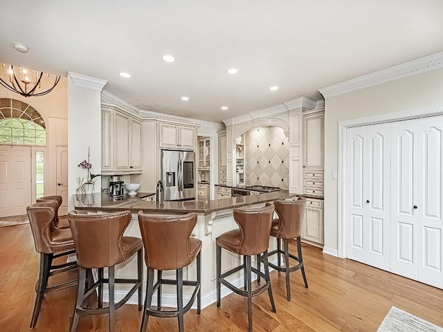 906 Big Bear Ct, Adams Twp, PA 15044 - kitchen with stainless steel fridge with ice dispenser, a peninsula, a kitchen bar, light wood-type flooring, and recessed lighting