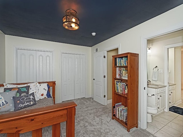 906 Big Bear Ct, Adams Twp, PA 15044 - bedroom with multiple closets, a sink, ensuite bath, baseboards, and light carpet