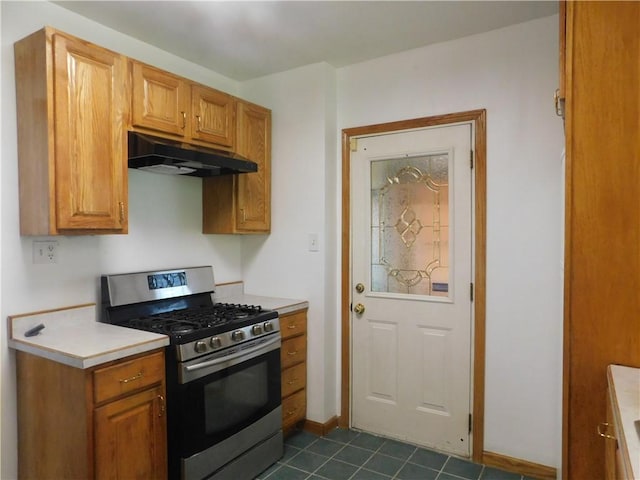 2300 Fairland St, Overbrook, PA 15210 - kitchen with gas range, under cabinet range hood, light countertops, and dark tile patterned floors