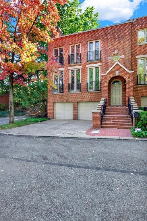 222 Schenley Rd, Squirrel Hill, PA 15217 - view of front of property featuring brick siding, an attached garage, concrete driveway, and a balcony