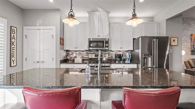155 Bucktail Dr, Cranberry Twp, PA 16066 - kitchen featuring stainless steel appliances, tasteful backsplash, an island with sink, white cabinetry, and hanging light fixtures