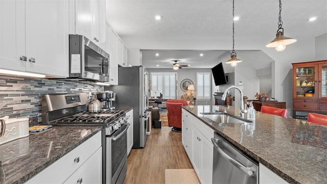 155 Bucktail Dr, Cranberry Twp, PA 16066 - kitchen featuring appliances with stainless steel finishes, a sink, open floor plan, ceiling fan, and decorative backsplash
