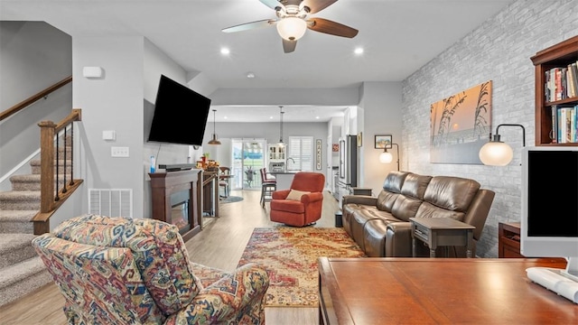 155 Bucktail Dr, Cranberry Twp, PA 16066 - living room featuring a glass covered fireplace, a ceiling fan, light wood-style floors, stairway, and recessed lighting
