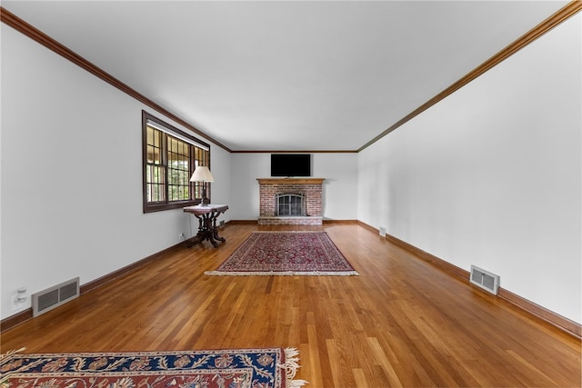221 Moody Rd, Imperial, PA 15126 - unfurnished living room featuring crown molding, wood finished floors, a brick fireplace, and baseboards